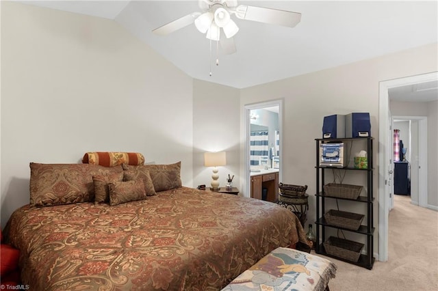 bedroom with lofted ceiling, light colored carpet, ensuite bathroom, and ceiling fan