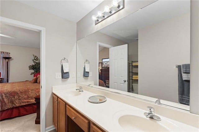 ensuite bathroom with a sink, ensuite bath, and double vanity