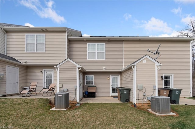 rear view of house featuring a patio area, central air condition unit, and a lawn