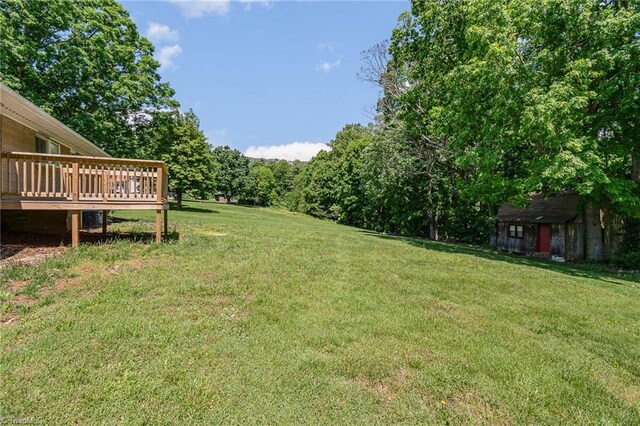 view of grassy yard with a wooden deck