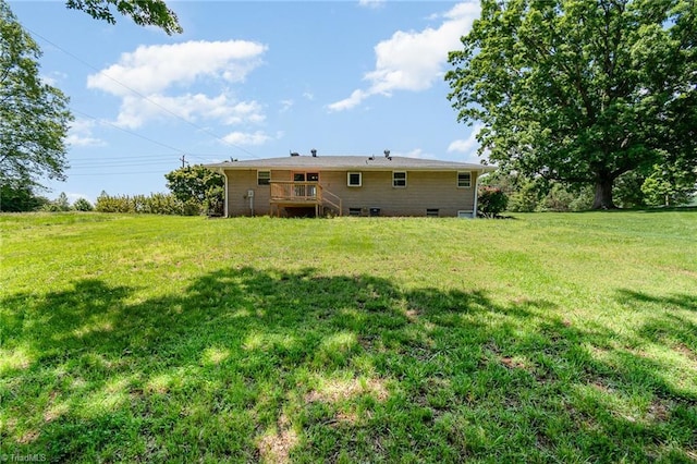 view of grassy yard with stairway and a wooden deck