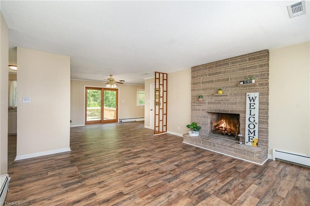 unfurnished living room featuring wood finished floors, a brick fireplace, a ceiling fan, baseboards, and a baseboard heating unit