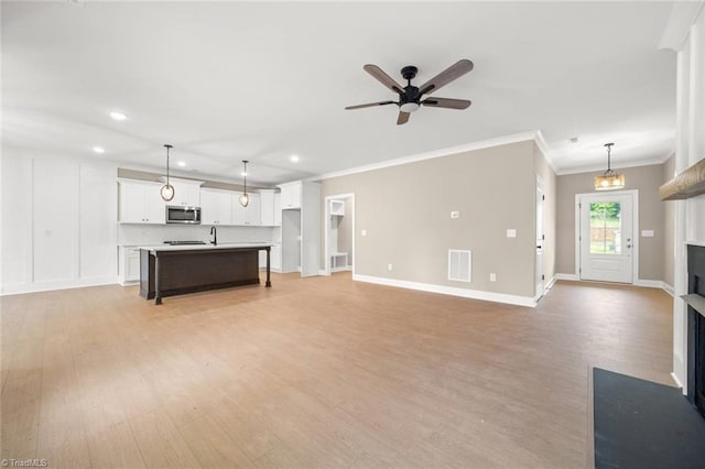 6957 Orchard Path Dr, Clemmons, NC 27012 - unfurnished living room featuring light wood-style flooring, recessed lighting, a fireplace, crown molding, and a ceiling fan
