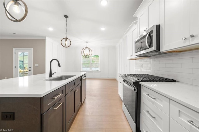 6957 Orchard Path Dr, Clemmons, NC 27012 - kitchen with stainless steel appliances, a sink, white cabinets, light countertops, and decorative backsplash