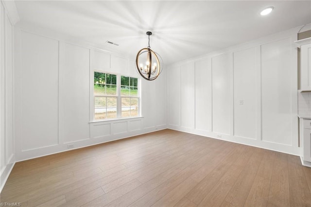 6957 Orchard Path Dr, Clemmons, NC 27012 - unfurnished room with a decorative wall, a chandelier, light wood-style flooring, and recessed lighting
