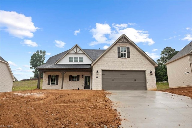 6957 Orchard Path Dr, Clemmons, NC 27012 - view of front of property featuring driveway, brick siding, covered porch, and an attached garage