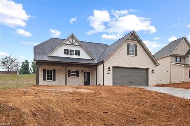 6957 Orchard Path Dr, Clemmons, NC 27012 - view of front of house featuring a porch, brick siding, driveway, a garage, and board and batten siding