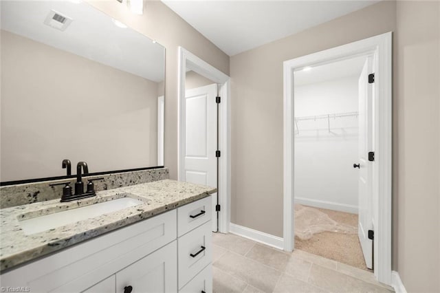 6957 Orchard Path Dr, Clemmons, NC 27012 - bathroom featuring vanity, a spacious closet, tile patterned flooring, and baseboards