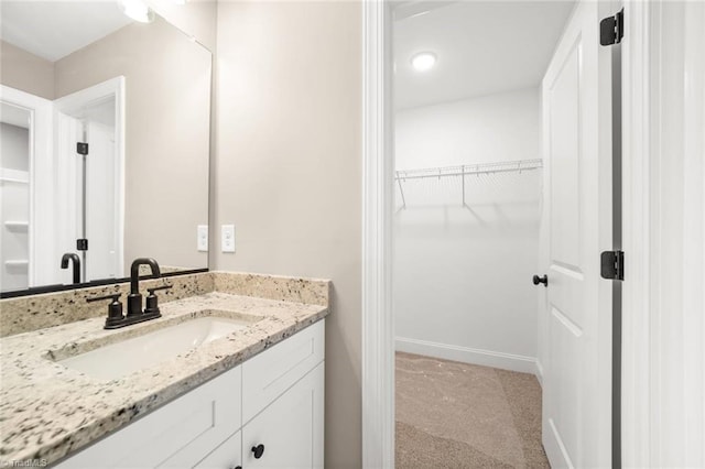6957 Orchard Path Dr, Clemmons, NC 27012 - bathroom featuring vanity, a spacious closet, and baseboards