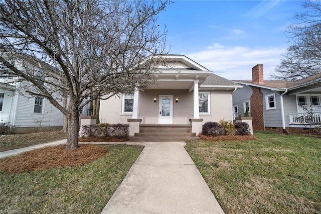 bungalow featuring a porch and a front lawn