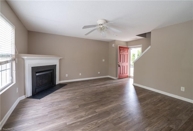 unfurnished living room with dark hardwood / wood-style floors and ceiling fan