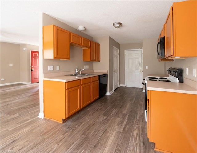 kitchen featuring hardwood / wood-style floors, black appliances, and sink