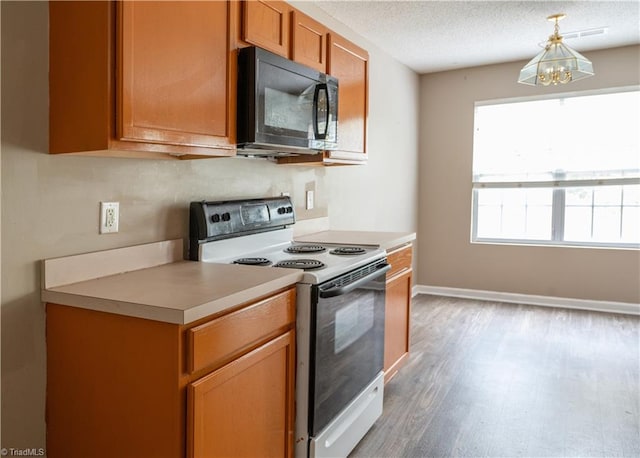 kitchen with white range oven, a chandelier, a textured ceiling, and hardwood / wood-style flooring