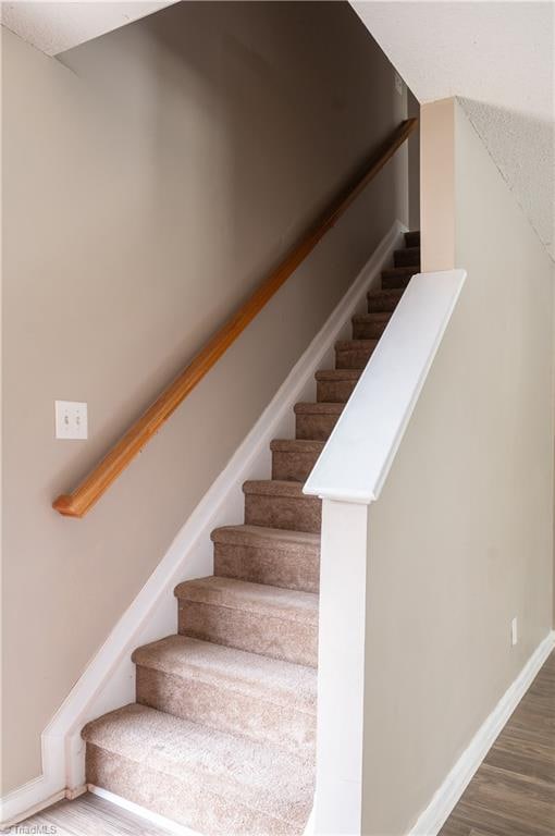 stairs featuring hardwood / wood-style flooring