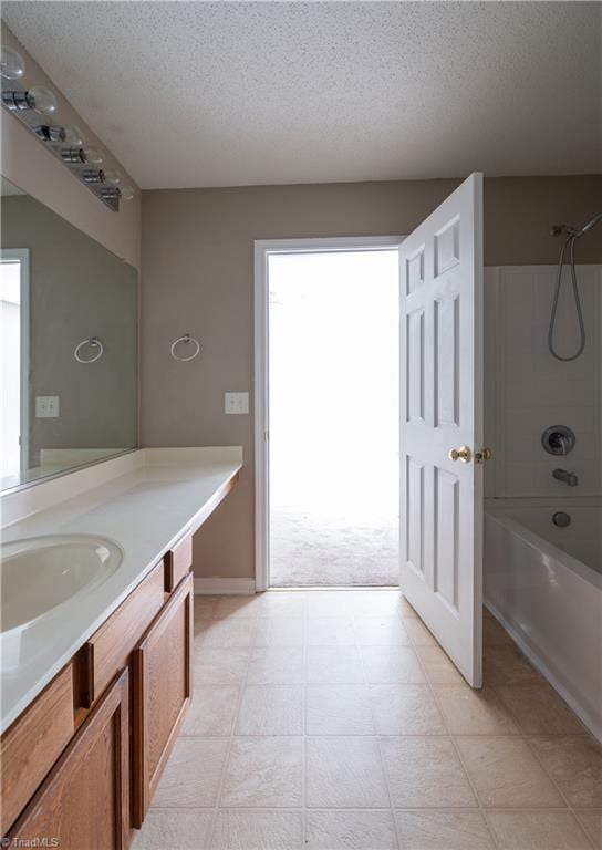 bathroom featuring bathing tub / shower combination, vanity, and a textured ceiling