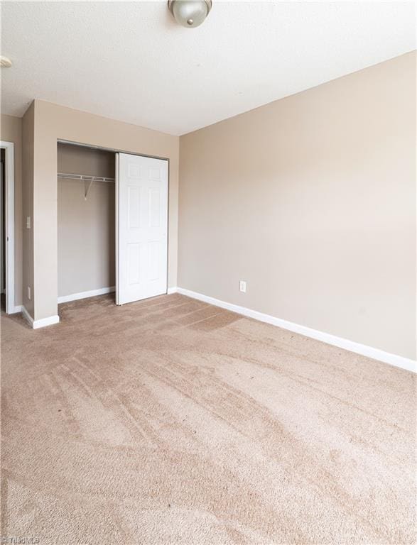 unfurnished bedroom with carpet and a closet