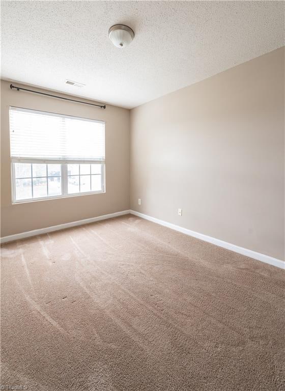 unfurnished room featuring a textured ceiling and carpet