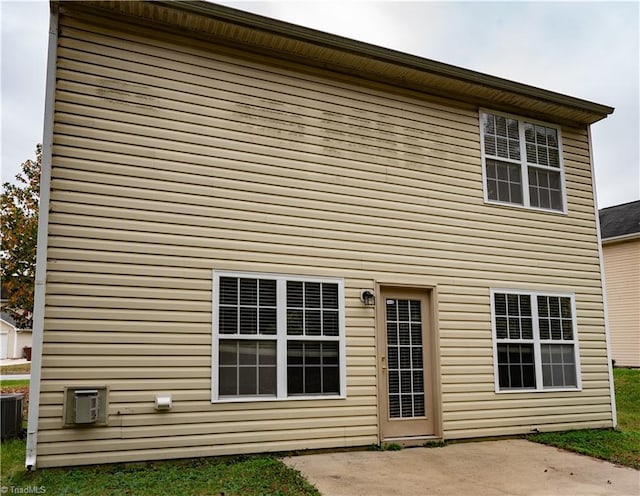 rear view of property with central AC unit and a patio