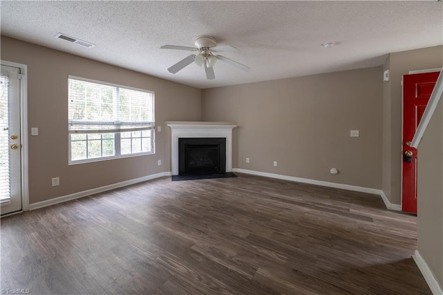 unfurnished living room featuring dark hardwood / wood-style flooring, a textured ceiling, and ceiling fan