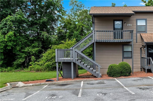 170 Vista Cir Unit C, Winston-Salem, NC 27106 - view of property exterior with stairs, uncovered parking, a shingled roof, and a lawn