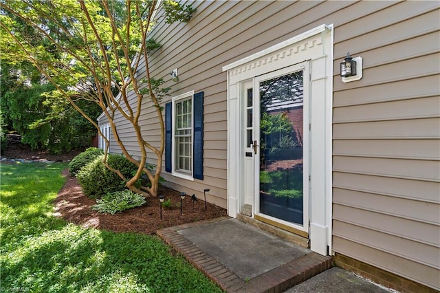 property entrance with a lawn