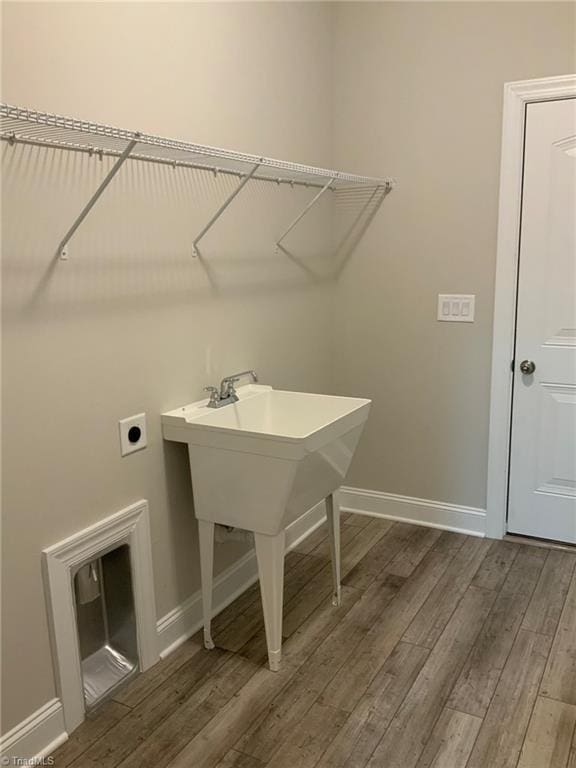 washroom featuring laundry area, electric dryer hookup, baseboards, and wood finished floors