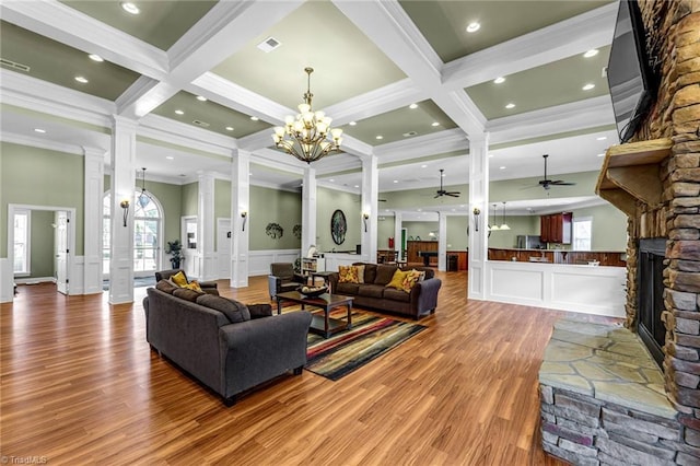 living room featuring a healthy amount of sunlight, a fireplace, beam ceiling, and ornate columns