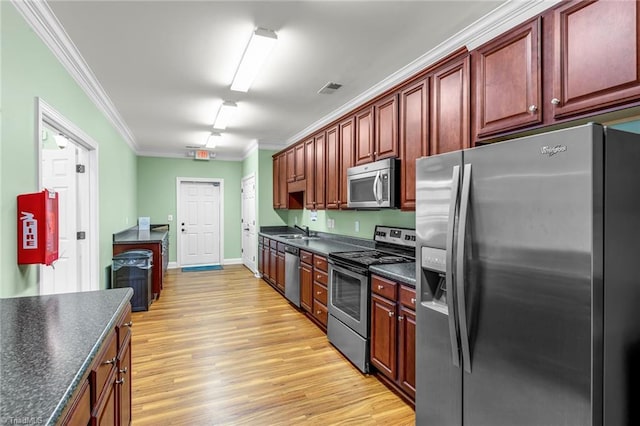 kitchen with a sink, visible vents, ornamental molding, appliances with stainless steel finishes, and dark countertops