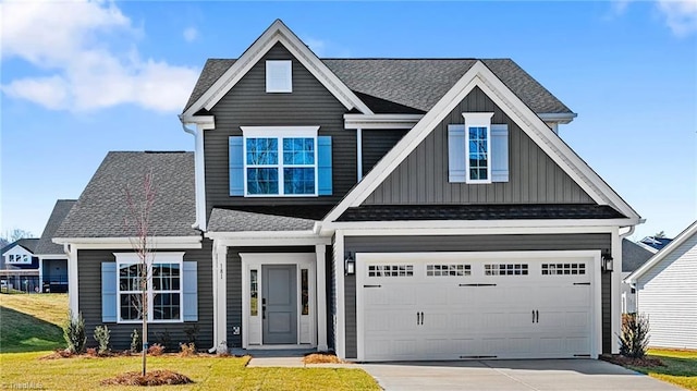 view of front of home with a shingled roof, board and batten siding, a front yard, a garage, and driveway