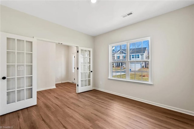 unfurnished room with french doors and wood-type flooring