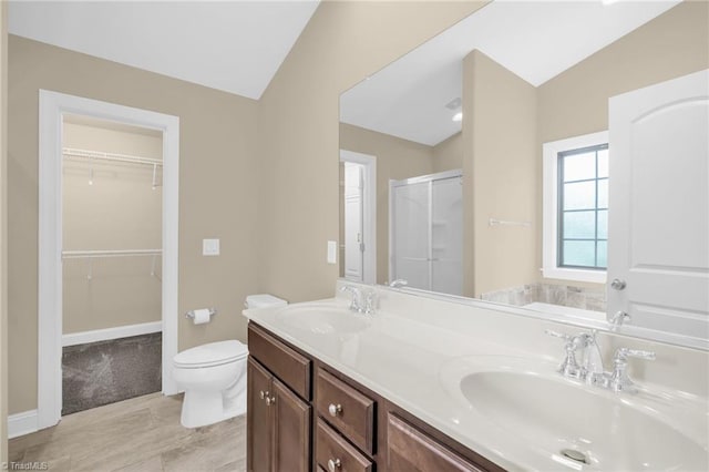 1604 Sunny Hill Way, Colfax, NC 27235 - bathroom with lofted ceiling, toilet, a shower stall, double vanity, and a walk in closet