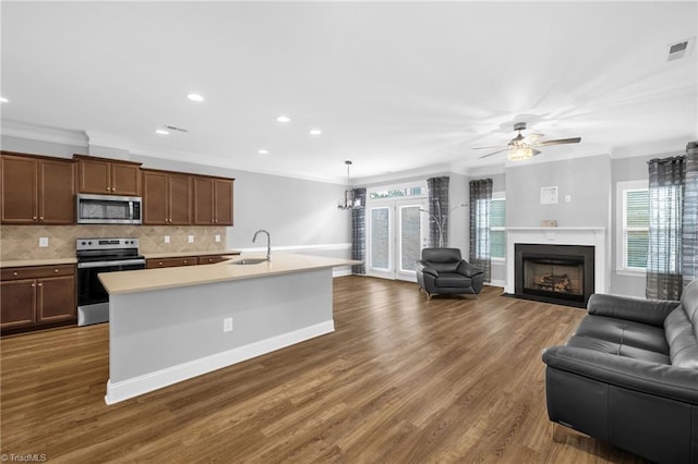 1604 Sunny Hill Way, Colfax, NC 27235 - kitchen featuring appliances with stainless steel finishes, a sink, open floor plan, light countertops, and crown molding