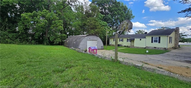 3613 Mcconnell Rd, Greensboro, NC 27405 - view of grassy yard with driveway, a detached garage, and an outbuilding