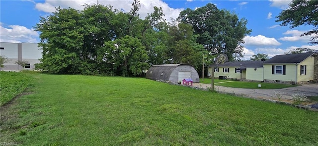 3613 Mcconnell Rd, Greensboro, NC 27405 - view of green lawn with a garage, driveway, and a storage shed