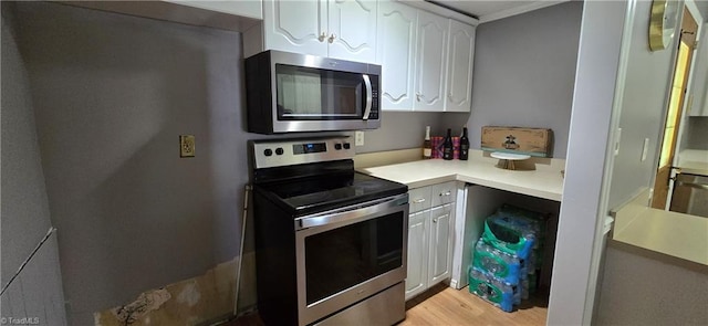 3613 Mcconnell Rd, Greensboro, NC 27405 - kitchen featuring stainless steel appliances, white cabinetry, light countertops, and light wood-style flooring