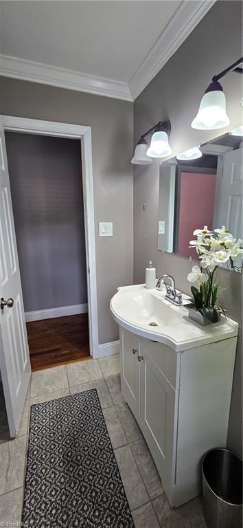 3613 Mcconnell Rd, Greensboro, NC 27405 - bathroom featuring crown molding, vanity, and marble look tile flooring