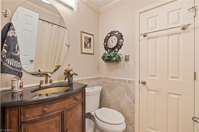 full bathroom with crown molding, tile walls, a wainscoted wall, vanity, and toilet