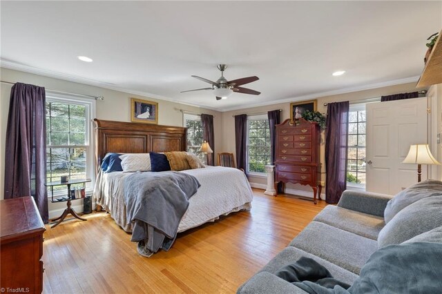 bedroom featuring recessed lighting, multiple windows, ornamental molding, and light wood-type flooring