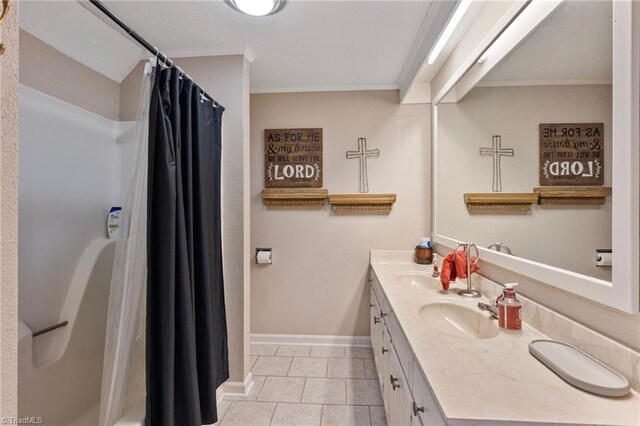 full bath featuring tile patterned flooring, vanity, baseboards, a shower with curtain, and ornamental molding