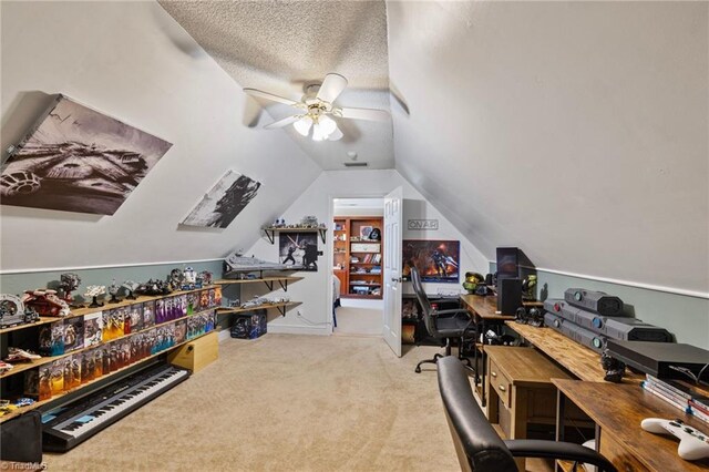 carpeted home office with ceiling fan and vaulted ceiling
