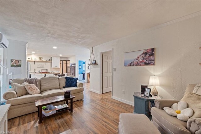 living room featuring baseboards, ornamental molding, and wood finished floors