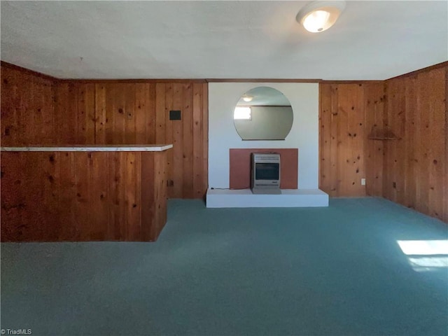 unfurnished living room with heating unit, wood walls, a dry bar, and carpet flooring