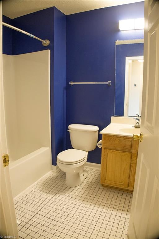 full bathroom featuring tile patterned floors, vanity, toilet, and shower / washtub combination