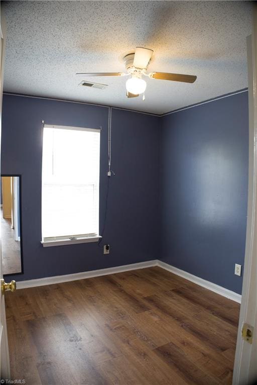 unfurnished room featuring a textured ceiling, dark hardwood / wood-style floors, and ceiling fan