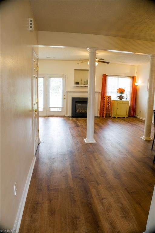 unfurnished living room with ceiling fan and dark hardwood / wood-style flooring