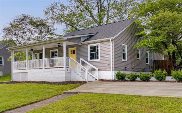 view of front of house featuring a porch, fence, a front yard, ceiling fan, and a shingled roof