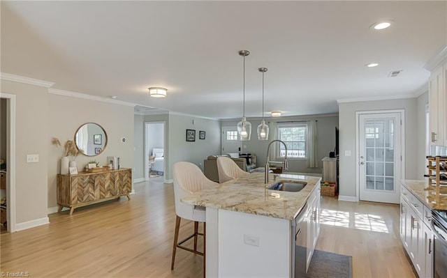 kitchen featuring a sink, crown molding, a breakfast bar, and white cabinets