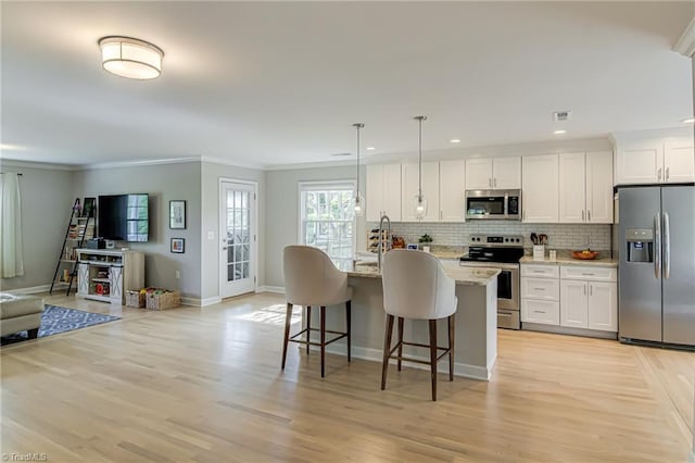 kitchen with baseboards, ornamental molding, light wood finished floors, decorative backsplash, and appliances with stainless steel finishes