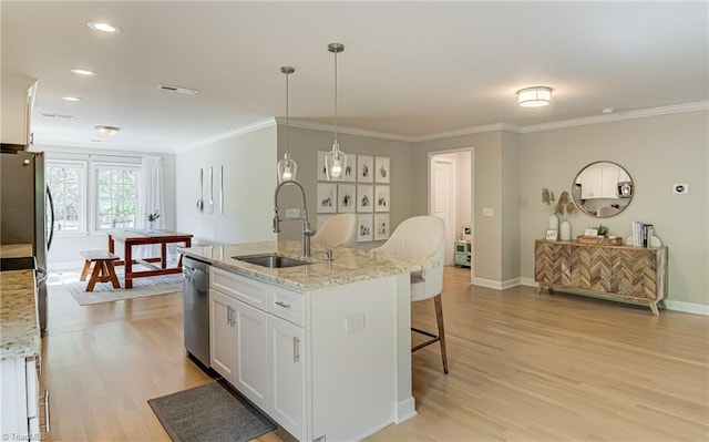 kitchen with ornamental molding, stainless steel appliances, a kitchen breakfast bar, and a sink