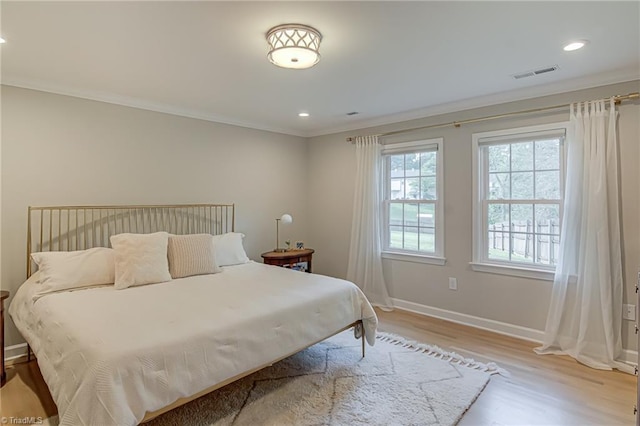 bedroom with wood finished floors, ornamental molding, visible vents, recessed lighting, and baseboards